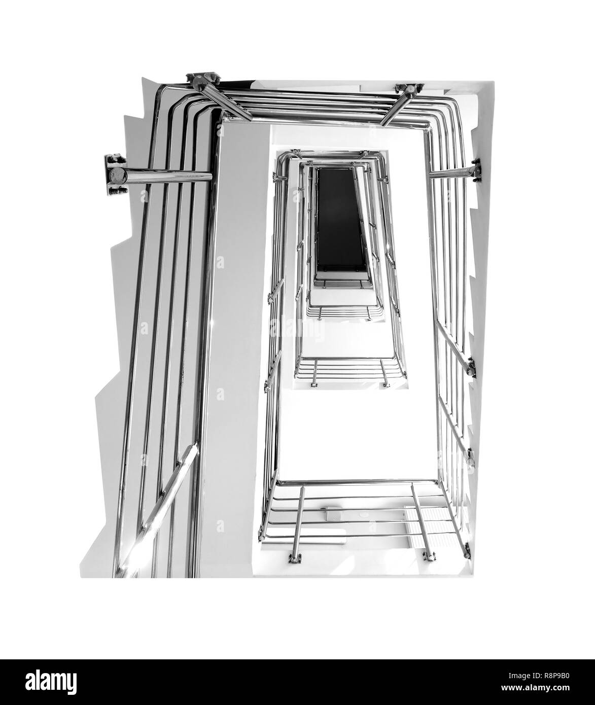 Escalier intérieur vide avec un garde-corps en métal, en allant vers le haut dans un bâtiment moderne avec des murs clairs. Photo en noir et blanc Banque D'Images