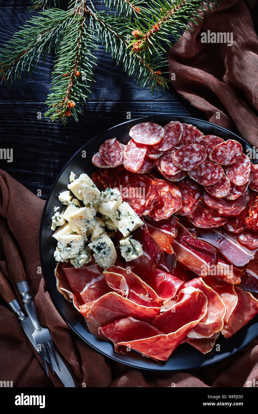 Antipasti de noël - fromage, saucisses et viandes salés à sec - jambon,  chorizo, fromage en tranches, la moisissure bleue saucisses fuet sur une  plaque sur une table avec tre sapin Photo