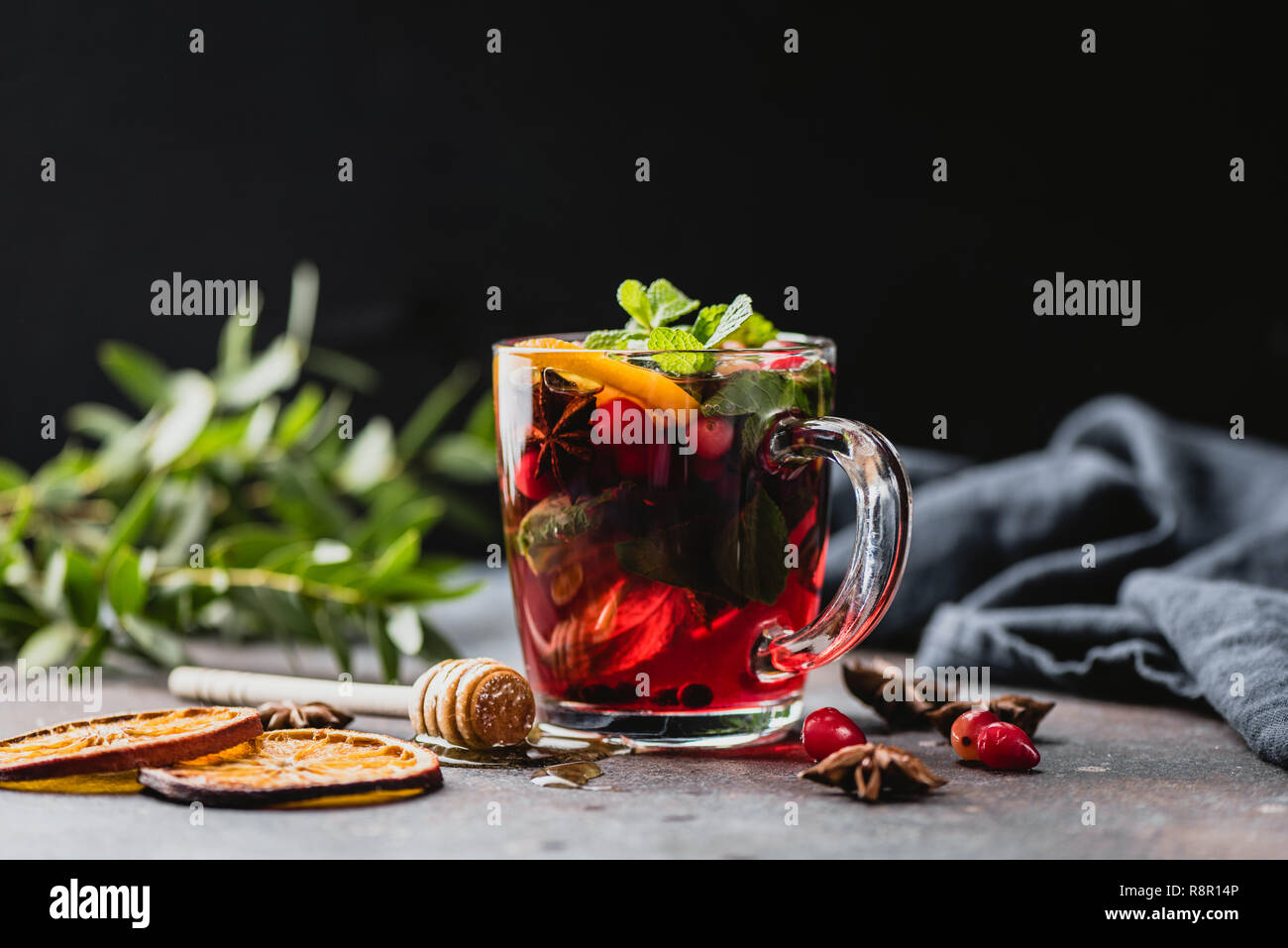 Le thé à la canneberge épicé chaud coupe verre sur fond noir. Réchauffement de la Noël, Nouvel An, l'hiver ou l'automne verre Banque D'Images