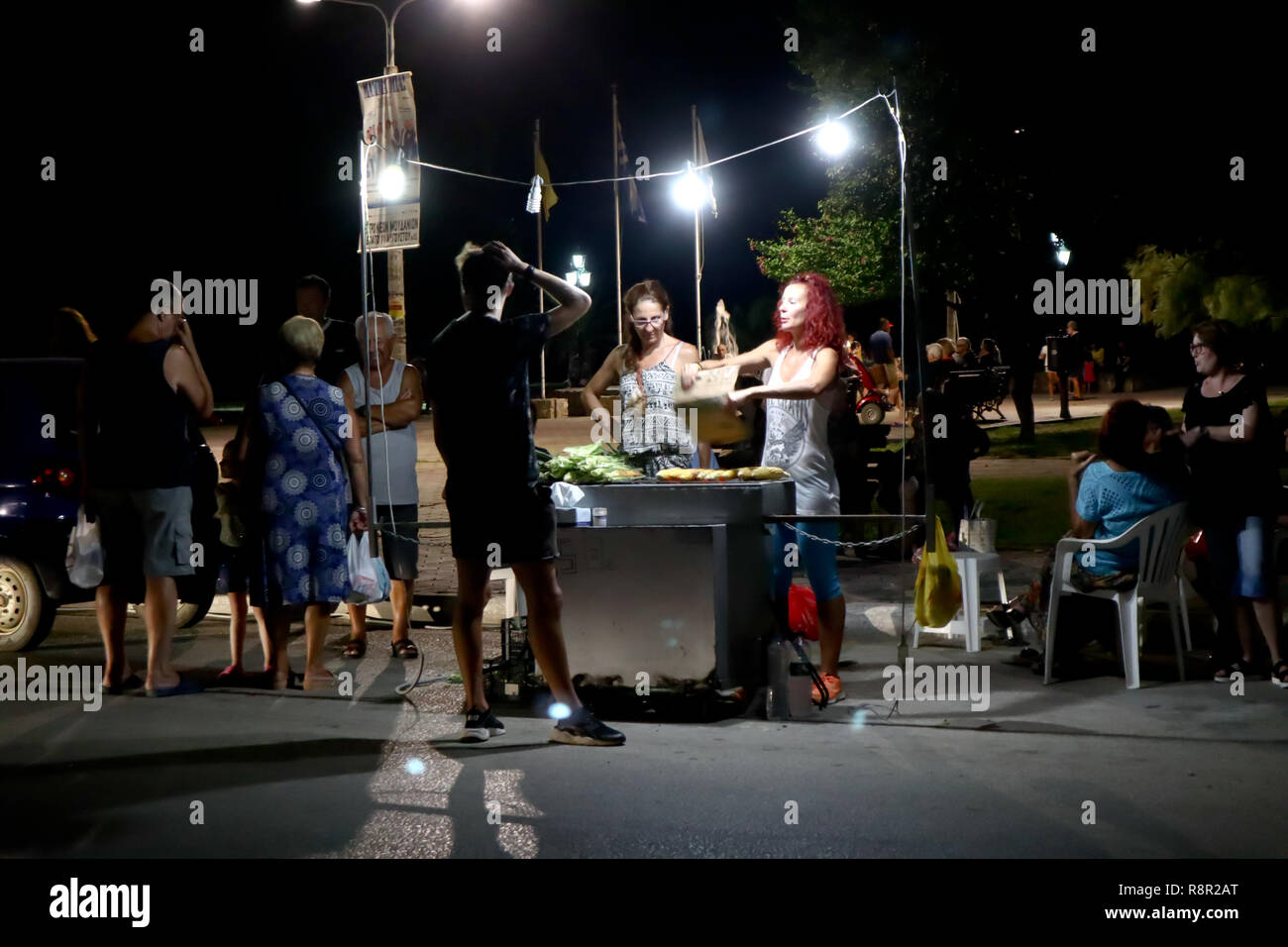 Dionysíou Paralía, 73110 Chania, Grèce, 07 août 2018 : stand de rue par nuit, les vendeurs de vendre aux acheteurs de maïs grillé Banque D'Images