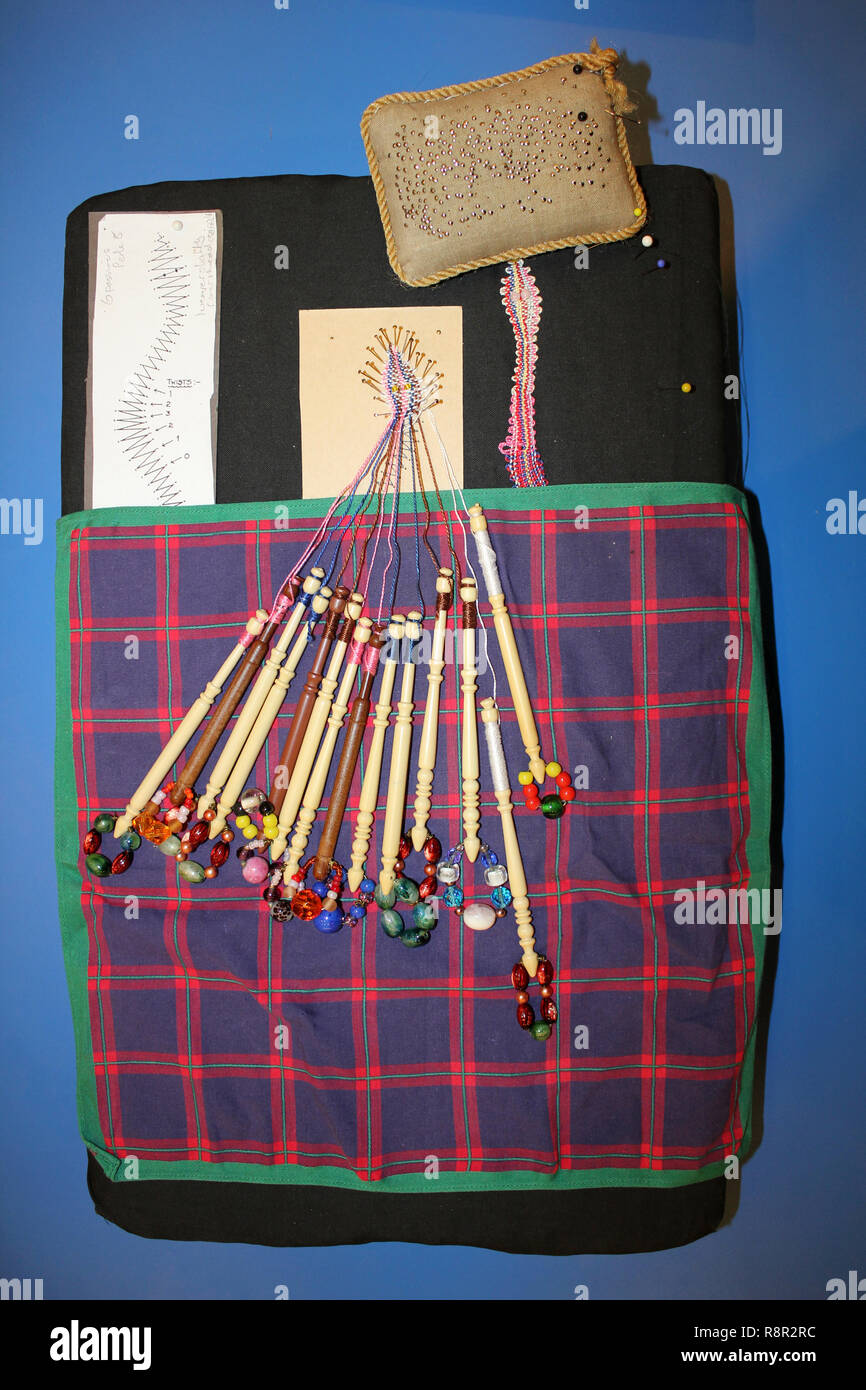 La Dentelle faite sur un oreiller avec bobines et les axes Banque D'Images