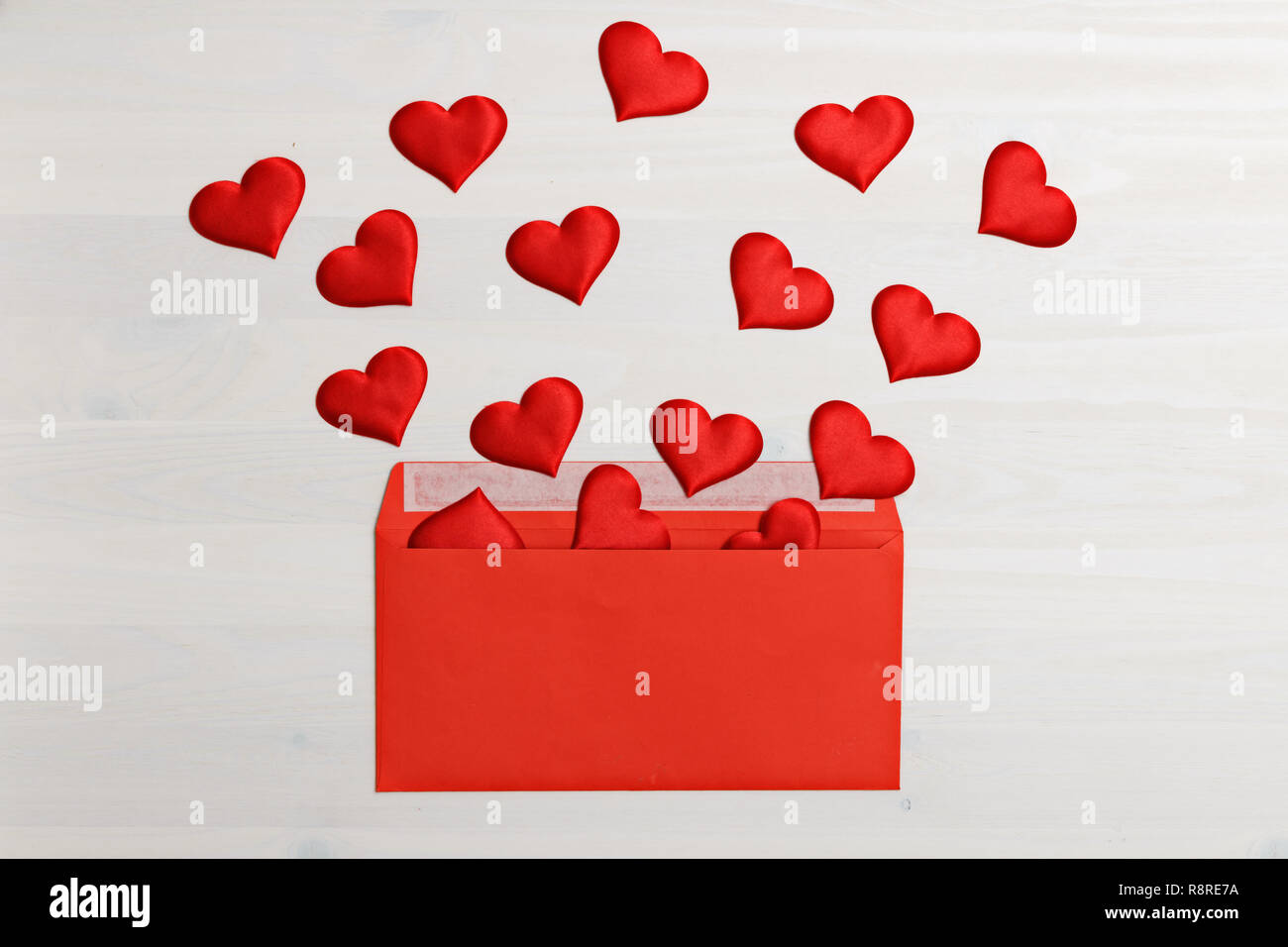 Libre de coeurs rouges en provenance d'une enveloppe de papier rouge sur un fond de bois blanc. Valentine's day celebration concept Banque D'Images