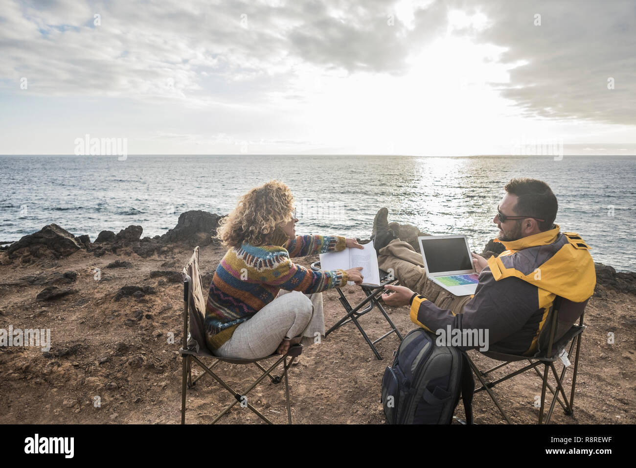 Une alternative moderne couple de meilleur homme et femme moyen-âge assis en face de l'océan le travail avec ordinateur internet ordinateur portable et l'étude de w Banque D'Images