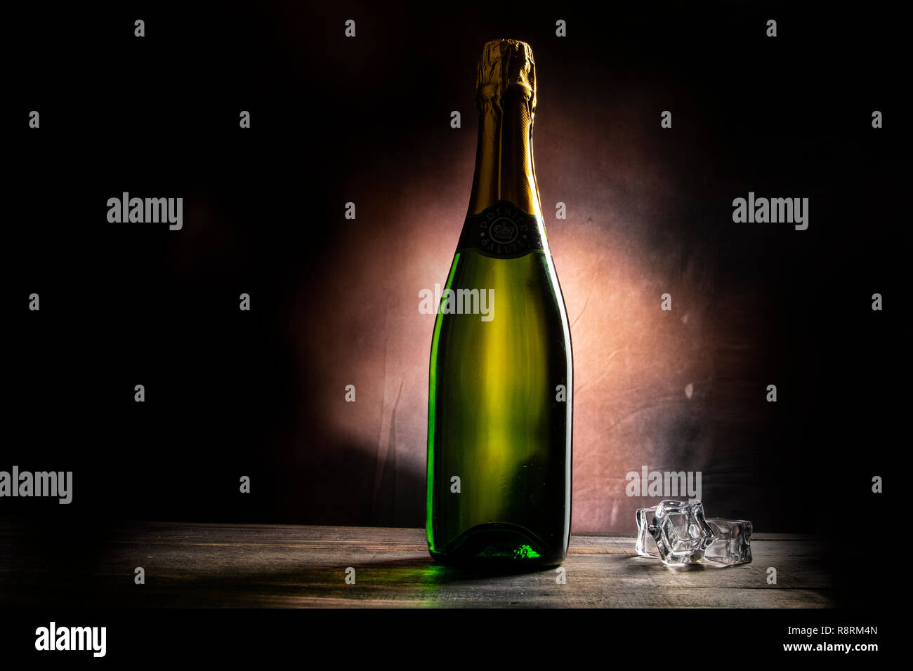 Bouteille de vin avec des cubes de glace sur table wodden Banque D'Images