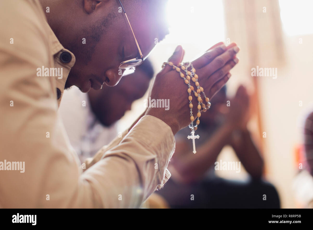 L'homme en prière avec le chapelet en groupe de prière Banque D'Images