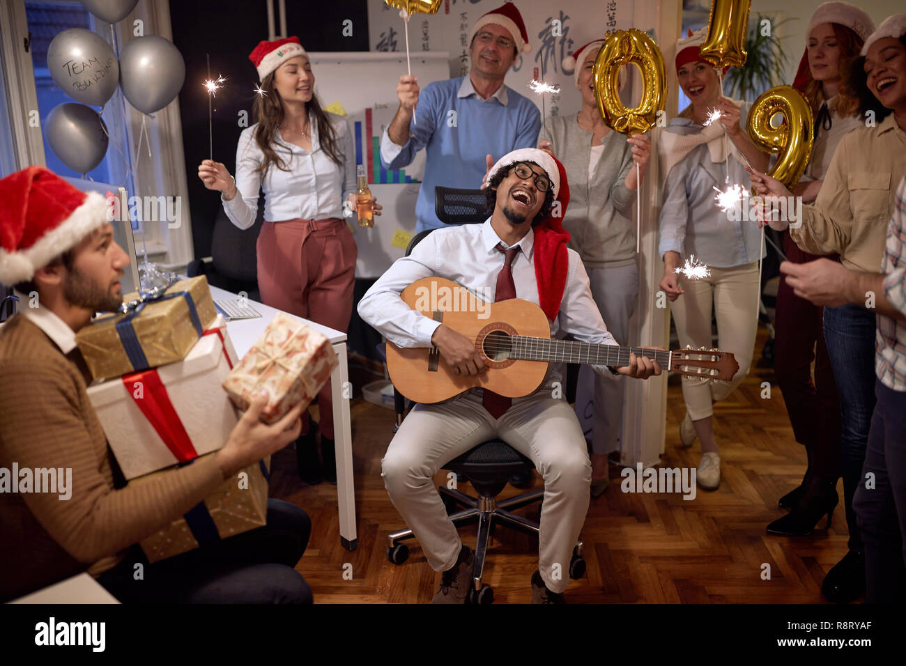 Groupe d'entreprises prospères ont in Santa hat à Noël parti au pouvoir célébrer avec la chanson Banque D'Images