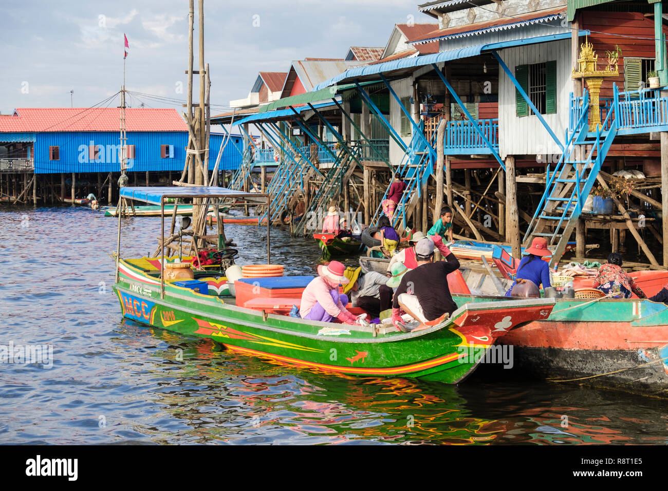 La population locale dans des bateaux à vendre des marchandises à l'extérieur des maisons sur pilotis au village flottant sur le lac Tonlé Sap. Kampong Phluk Indochine Asie Cambodge Siem Reap Banque D'Images