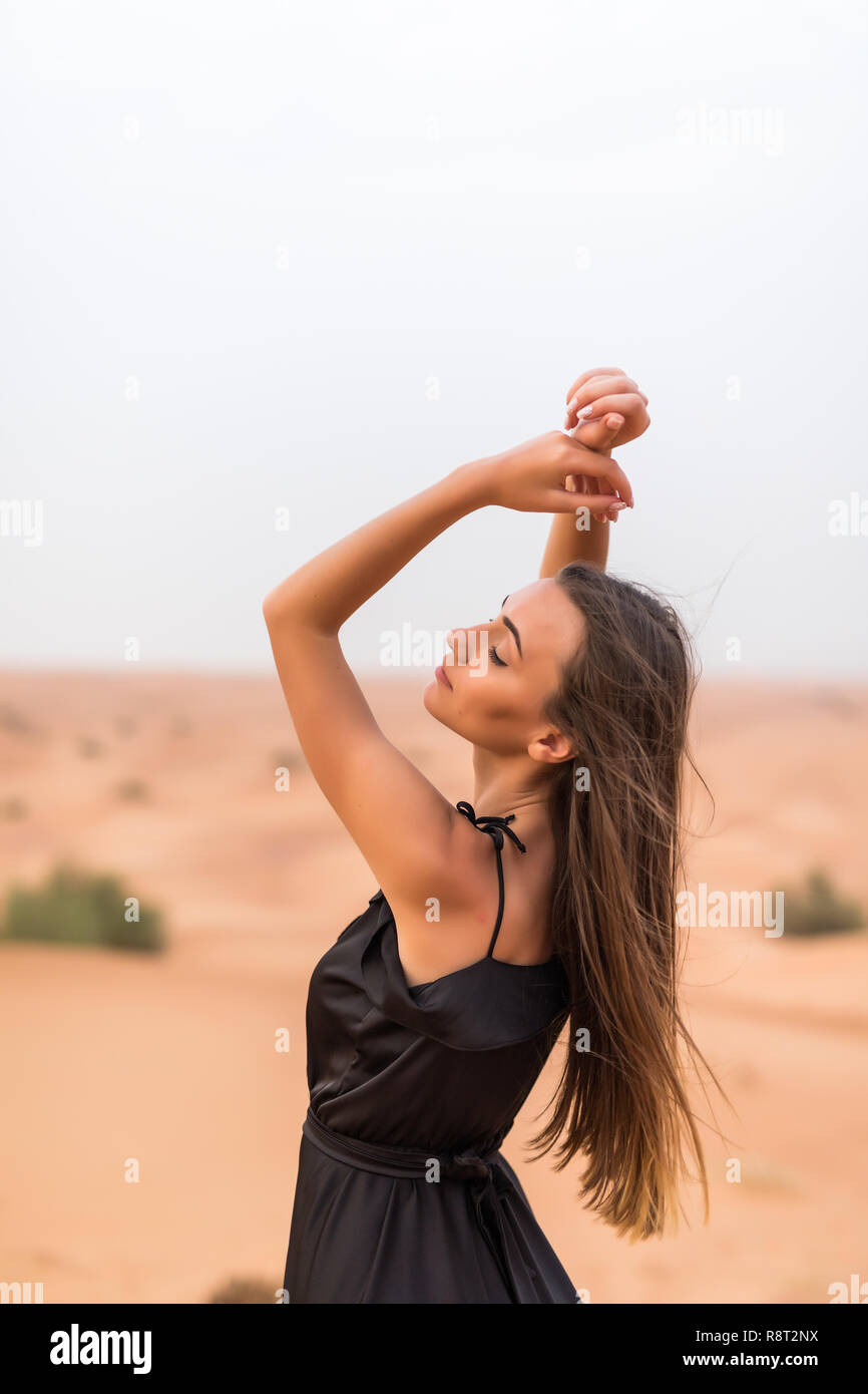 Belle jeune femme caucasienne posant dans une robe traditionnelle Emirati -  abaya dans désert du paysage. Abu Dhabi, EAU Photo Stock - Alamy