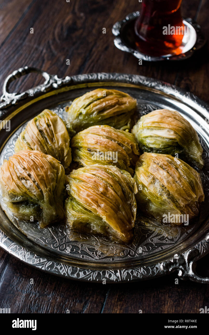 Baklava Midye turc ( Forme de moules ) Baklawa avec poudre de pistache vert, crème et beurre thé traditionnel dans le bac d'argent. Dessert à la Pistache Banque D'Images