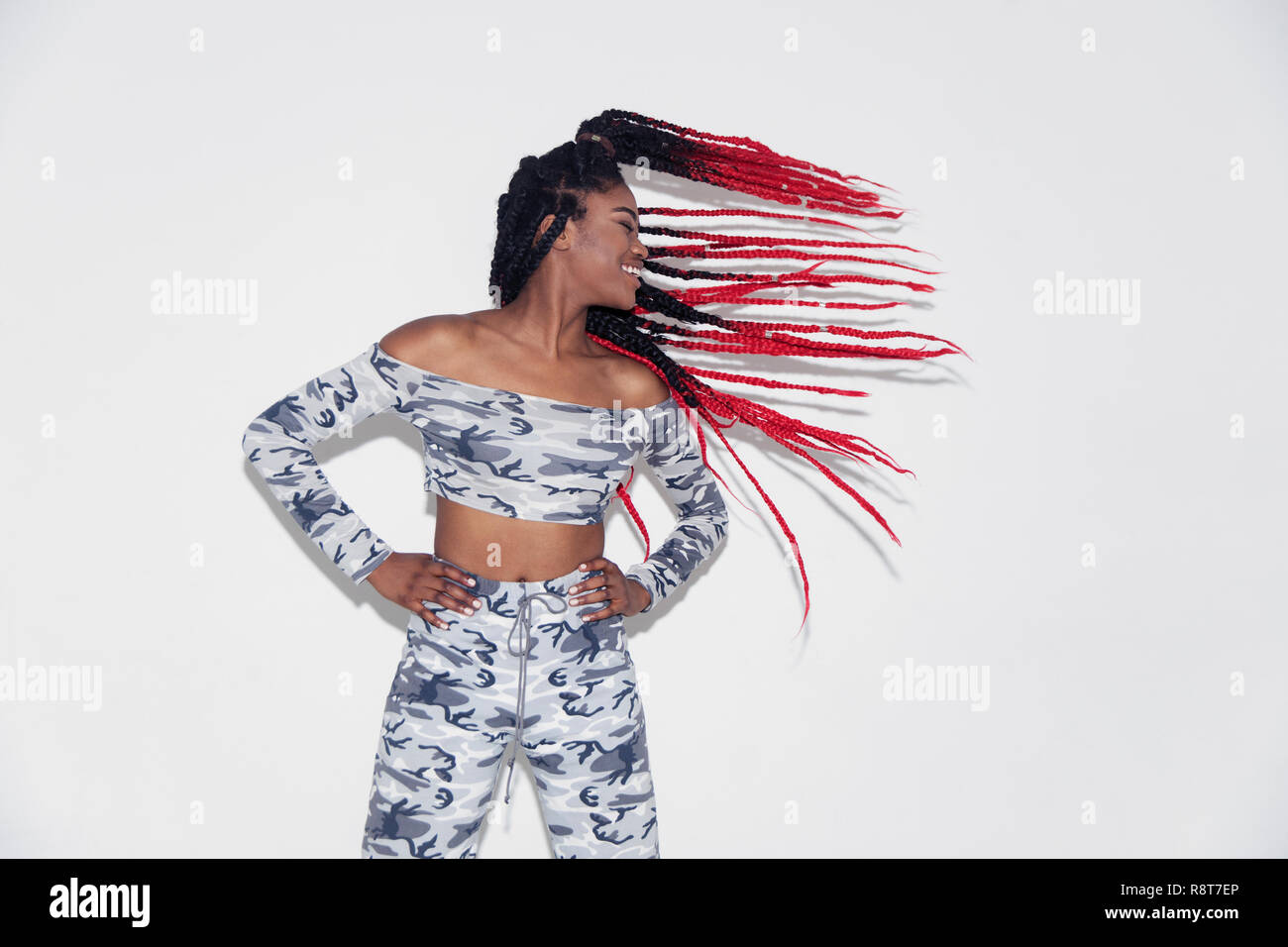 Jeune femme insouciante en camouflage flipping hair Banque D'Images
