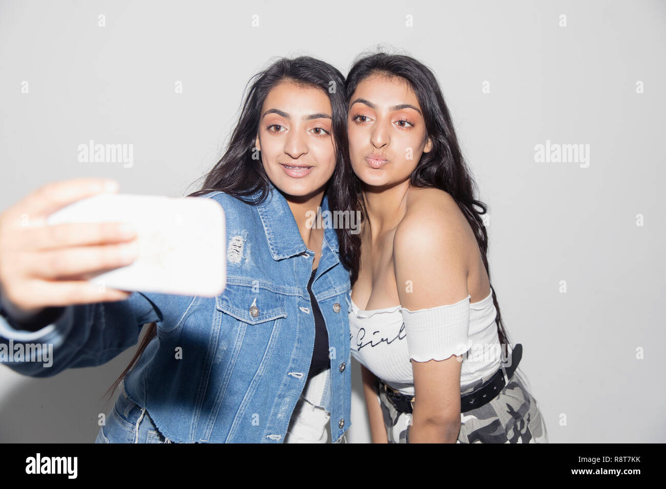 Les jumelles en tenant avec selfies smart phone Banque D'Images