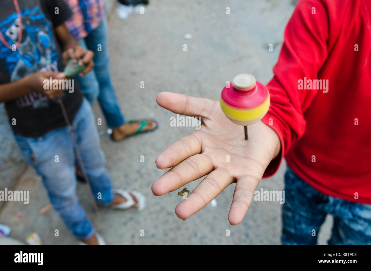 Jeune garçon indien de tourner une toupie sur sa main, Jodhpur, Inde Banque D'Images