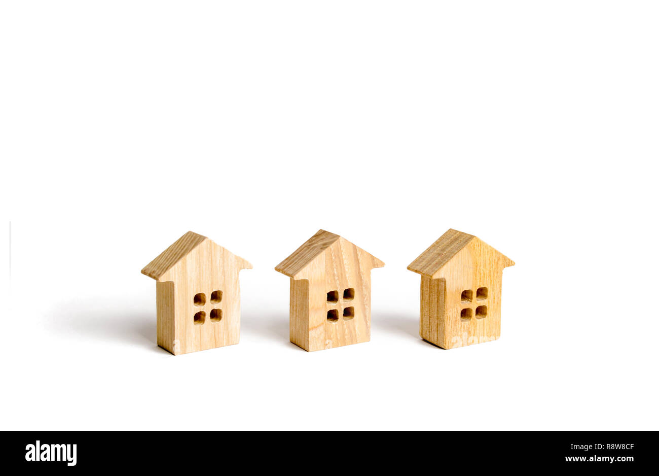 Trois figurines en bois de maisons sur un fond blanc. Copie du minimalisme et de l'espace. Le concept de l'immobilier, le logement, l'achat ou la vente, la location. Se Banque D'Images