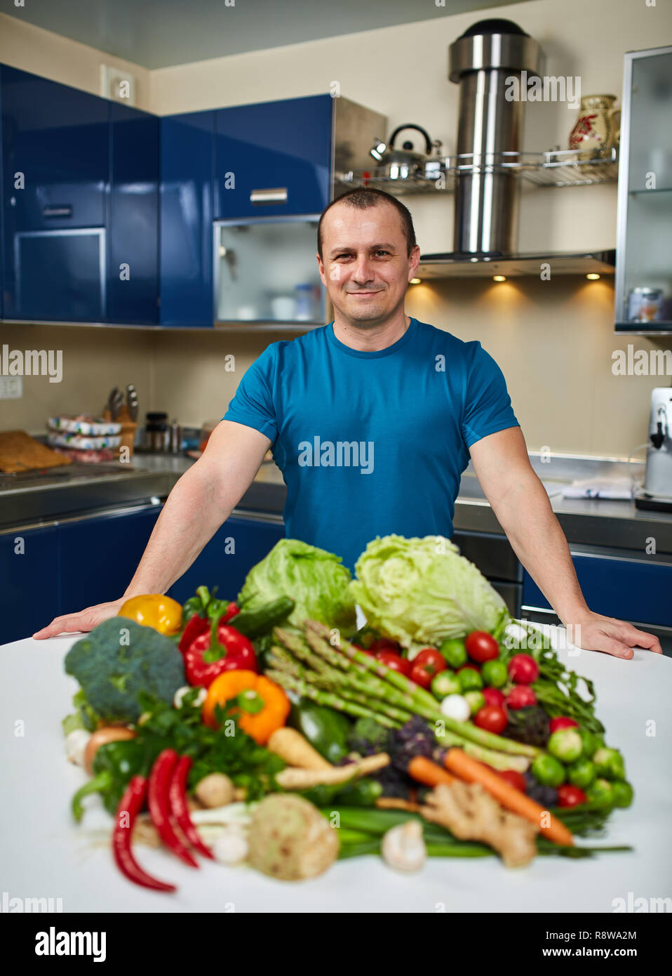 Homme avec une grande variété de légumes, prêts à être cuisinés Banque D'Images