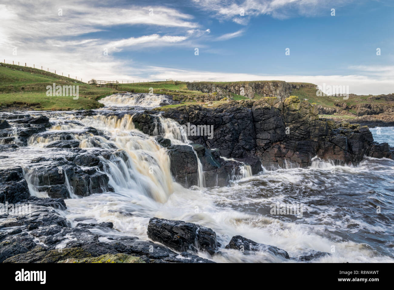 Il s'agit d'Dunseverick tombe sur la Côte d'Antrim, en Irlande du Nord. C'est un flux d'eau douce qui s'exécute dans l'océan. Il est à seulement quelques kilomètres de distance f Banque D'Images