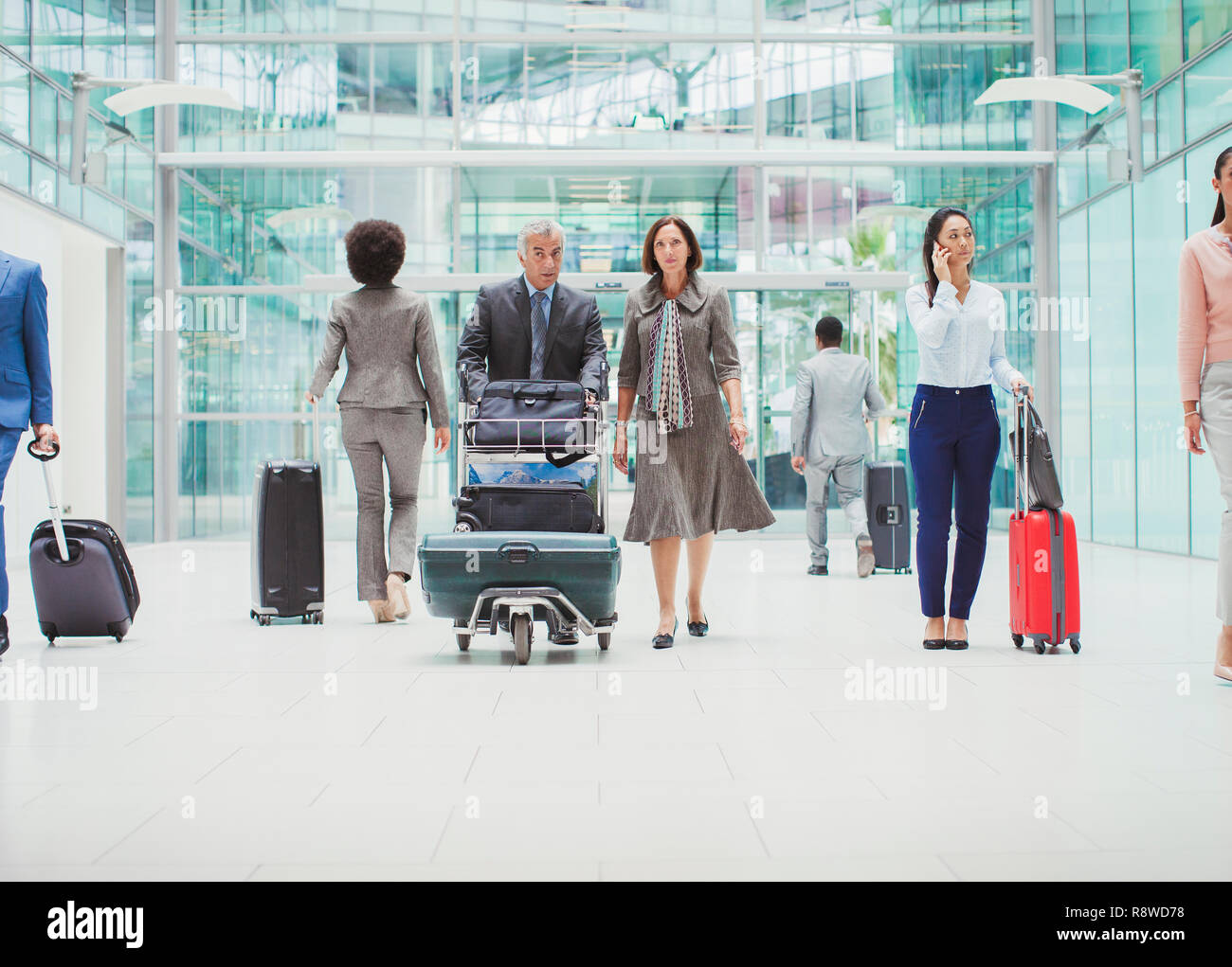 Les gens d'affaires à marcher avec assurance dans l'aéroport Banque D'Images