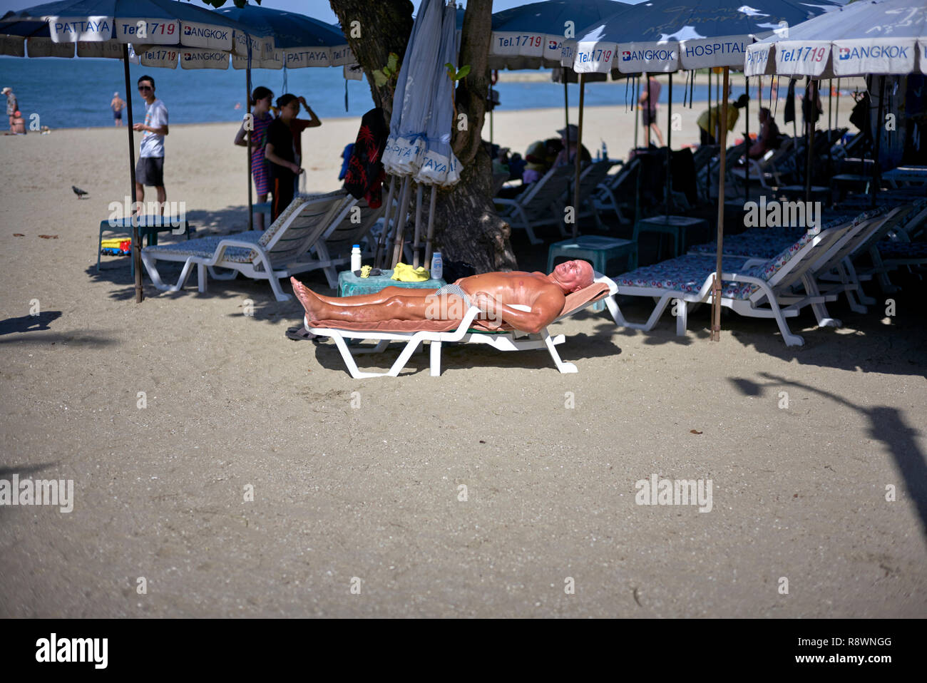 L'homme en train de bronzer sur une chaise longue ou un fauteuil inclinable à la plage à Pattaya, Thaïlande, Asie du Sud-Est Banque D'Images