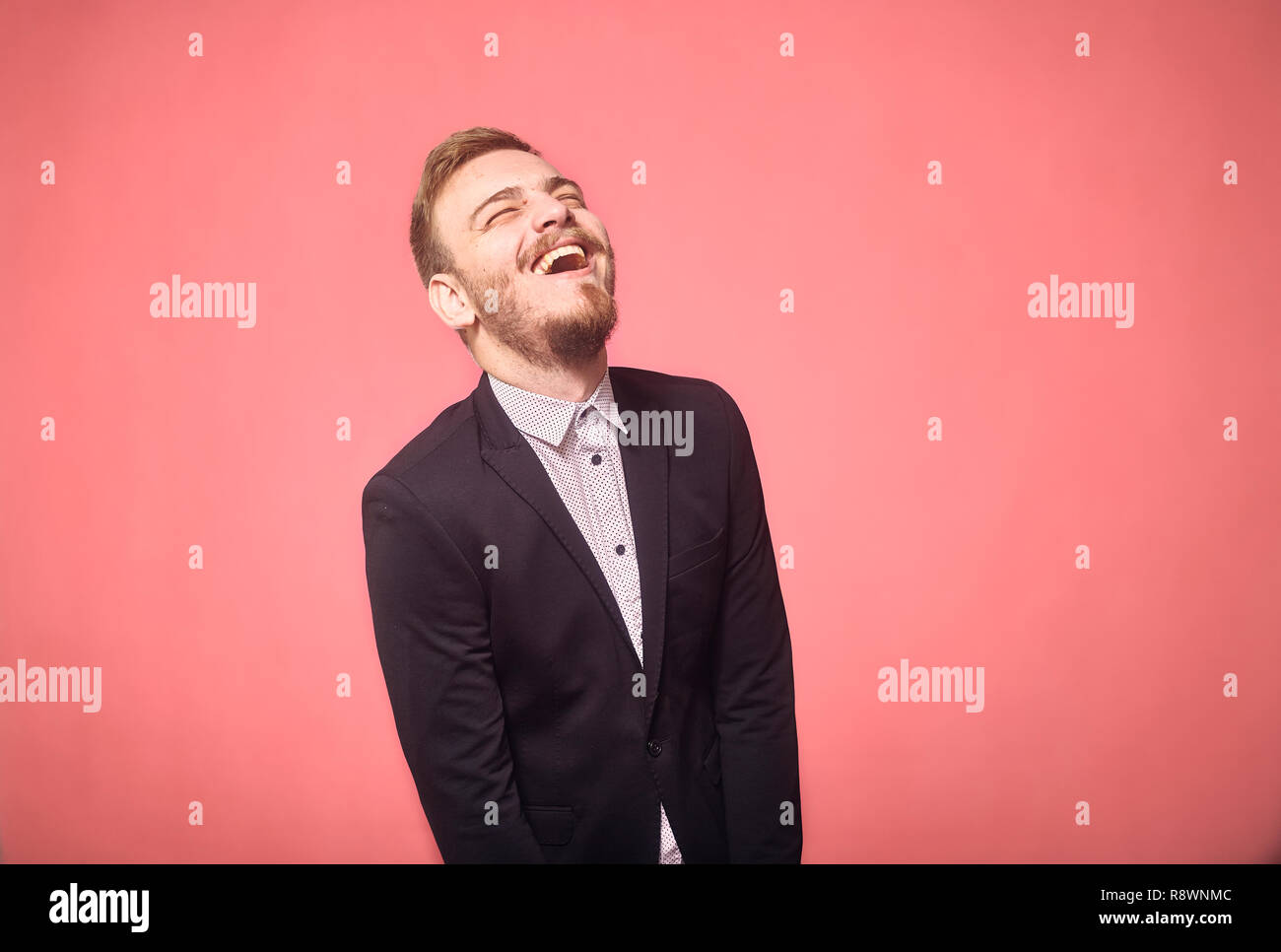 Un jeune homme, 29 ans, franc rire, rire. pink background, studio shot, séance photo. Banque D'Images