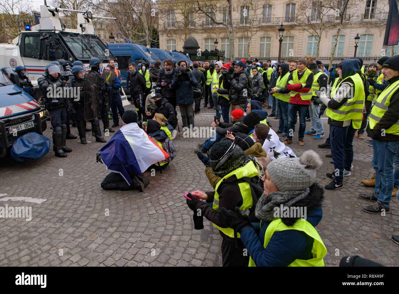 La police antiémeutes et jaune de démonstration (gilets jaunes) manifestants contre le gouvernement et le président français Macron à Champs-Élysées, Paris, France Banque D'Images