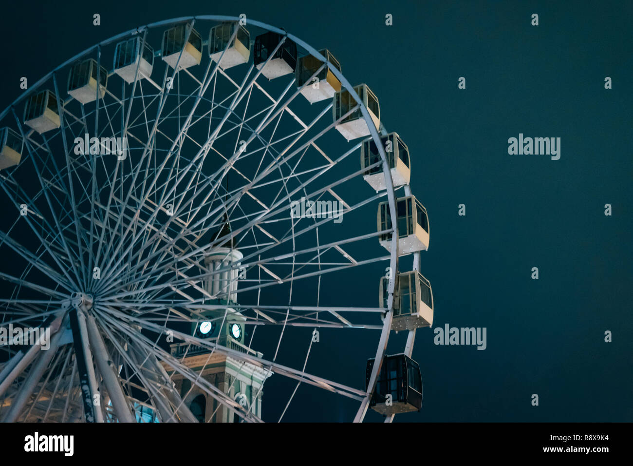 Grande roue à Kiev le sombre soir avec arrière-plan de l'architecture lumineuse Banque D'Images