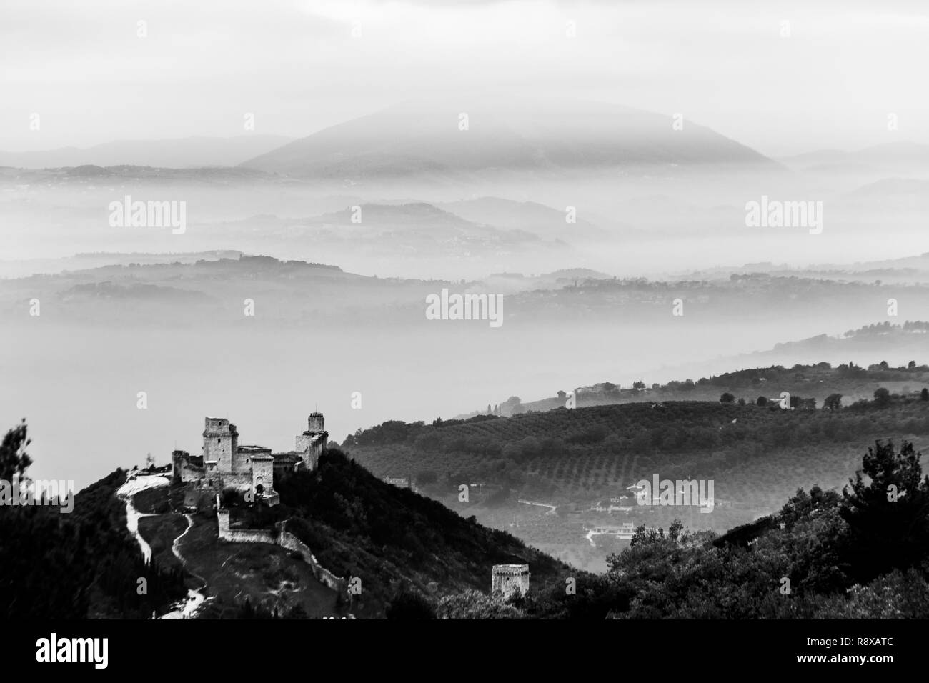 Belle vue sur le château de Rocca Maggior (Assise, Umbrfia, Italie) sur une mer de brume, avec des collines en arrière-plan Banque D'Images