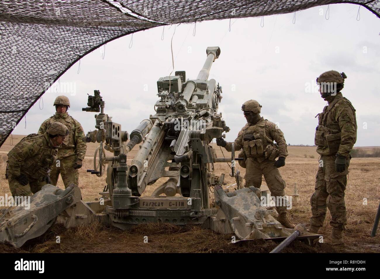 Quatre membres de l'équipe du canon pour la 1ère section, 1e Peloton, Cobra, de la batterie, de l'Escadron d'artillerie régiment de cavalerie 2d, de l'armée américaine, rester prêt à recevoir une mission de tir avec leur M777A2 Howitzer lors d'un 8 mars, 2017 dans la zone d'entraînement Grafenwoehr, Allemagne. L'Escadron a participé à l'avant dynamique II 6-9 mars, 2017. L'exercice a permis aux États-Unis, l'Allemagne et la République tchèque pour synchroniser leurs capacités d'artillerie. Banque D'Images