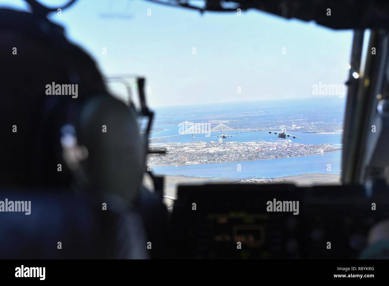 Le capitaine Bryce Weir, 15e Escadron de transport aérien, pilote exploite un C-17 Globemaster III au cours d'un vol à l'aérodrome auxiliaire en Amérique du Nord, Caroline du Sud, le 15 mars 2017 pour l'exécution de la formation en vol avec l'œil de l'équipage et du système de protection respiratoire (AERPS) de l'équipement. Le vol, pour la première fois en plus de 10 ans où des équipages d'AERPS portaient l'équipement. AERPS équipement consiste en un masque de caoutchouc, de multiples couches de bottes et de gants, filtre de ventilateur et système audio et un système d'enceintes. Banque D'Images