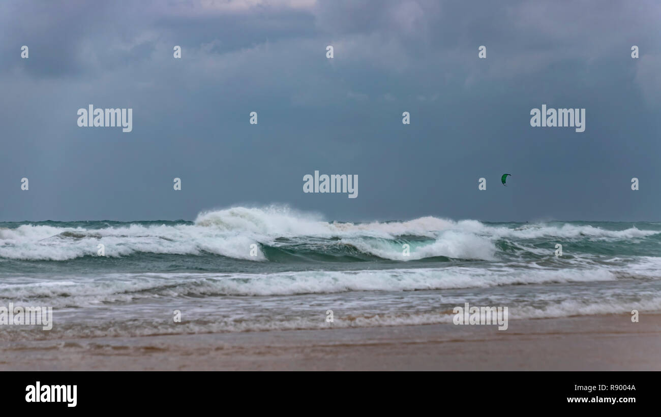 Surfer's parachute dans un ciel d'orage sur la mousse des vagues de la mer Méditerranée. Israël Banque D'Images