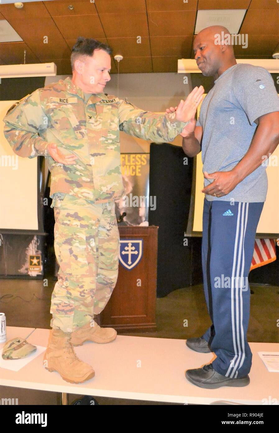 Garba "Mister G" Onadja, qui enseigne aux gens les avantages d'aliments nutritifs, en santé, en forme de vie, démontre au colonel Vince Riz, 653e groupe d'appui régional, commandant d'arts martiaux, au cours d'une session de préparation à l'échelle commande au Los Alamitos Joint Forces Training Base, 4 mars. Pour lancer "l'année de la remise en forme," le brigadier. Le général David E. Elwell, 311e Commandement de soutien expéditionnaire général commandant, a invité Tony Horton, un motivateur et un auteur de livres à succès, haut et Garba "Mister G" Onadja, qui enseigne aux gens les avantages d'aliments nutritifs, en santé, en forme lifest Banque D'Images