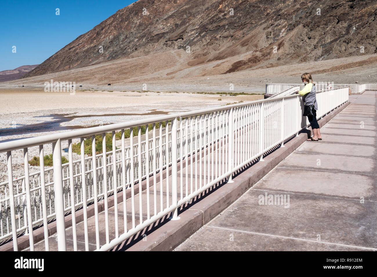 Les peuplements matures femme adulte par une clôture, profitant de la vue sur le bassin de Badwater dans Death Valley National Park, en Californie, le point le plus bas sous la mer lev Banque D'Images