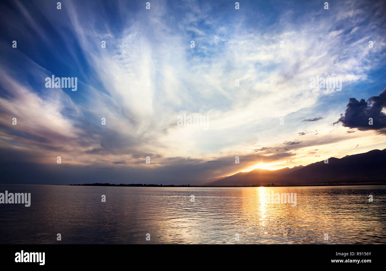 Le lac Issyk Kul au coucher du soleil nuageux ciel bleu à Cholpon Ata, Kirghizistan Banque D'Images