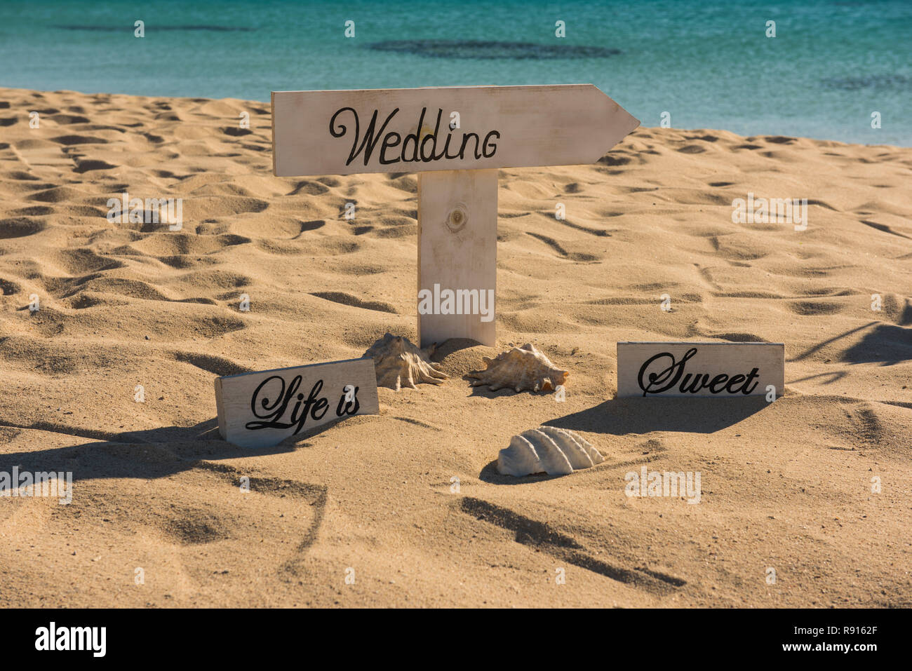 Gros plan du signe de mariage sur une plage de sable de l'île tropicale paradisiaque de l'océan avec en arrière-plan Banque D'Images