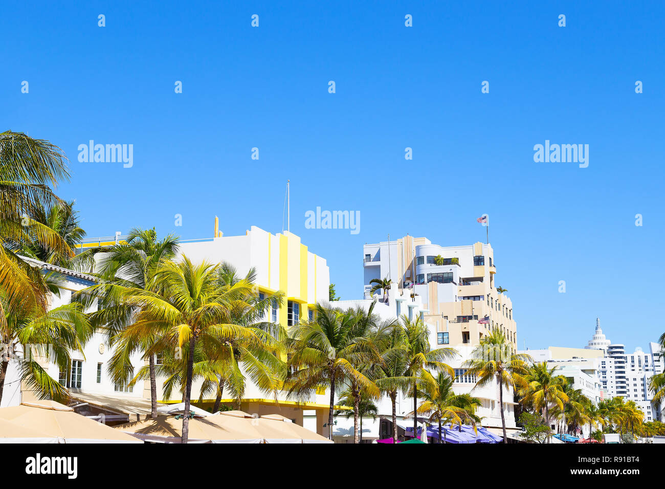 Bâtiments modernes de Miami Beach, en Floride. Rue avec des bâtiments art déco, des palmiers et des parasols colorés street. Banque D'Images