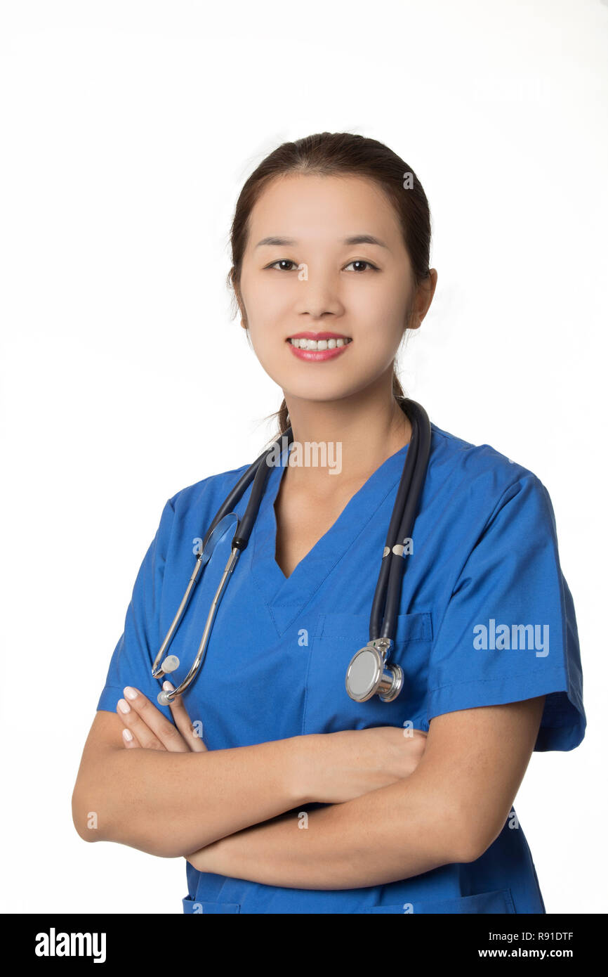 Belle Asiatique-américain médecin ou infirmière wearing blue scrubs et posant avec stéthoscope isolé sur fond blanc Banque D'Images