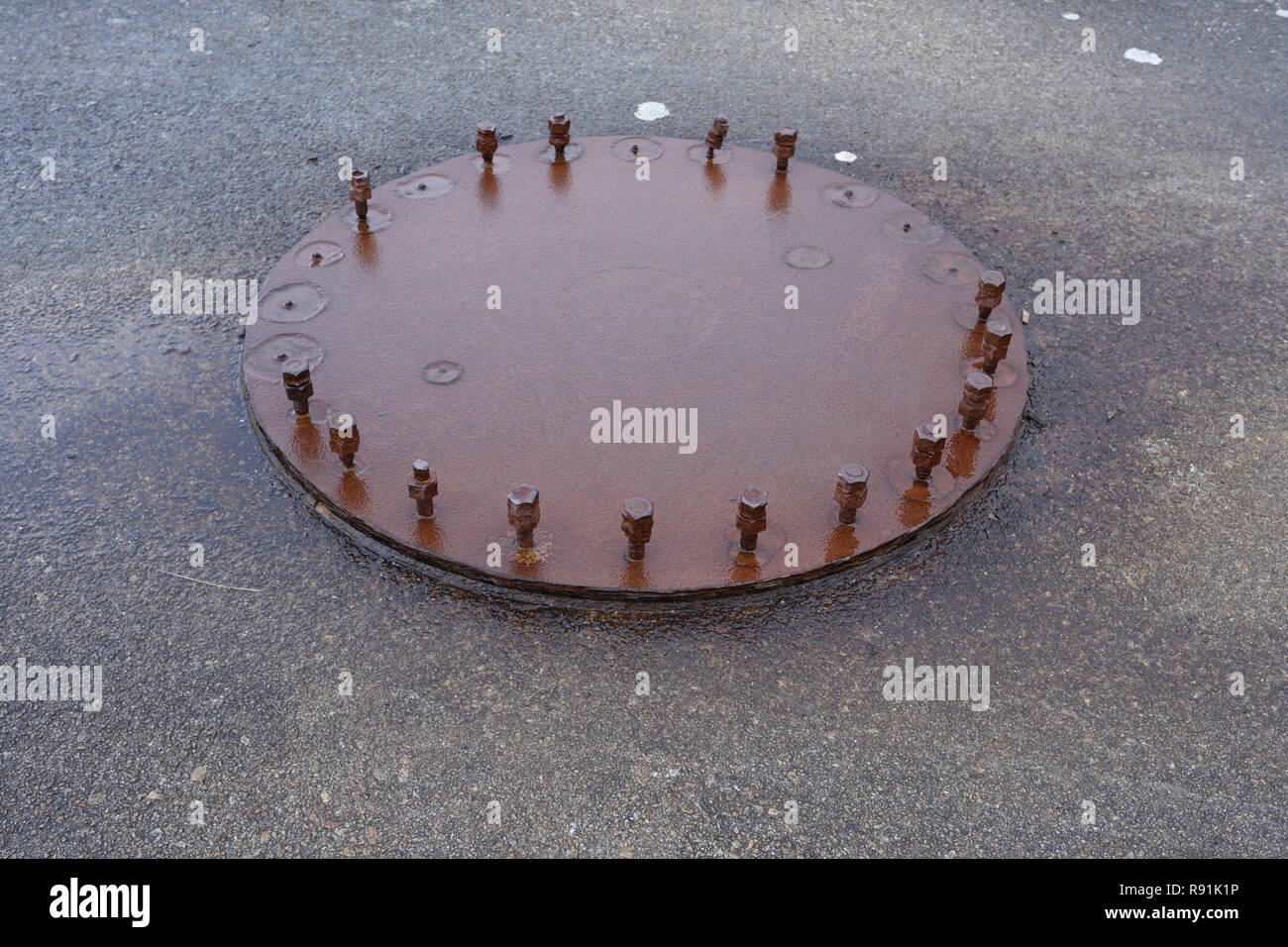 Plaque d'acier rouillé avec boulons et écrous en acier rouillé, sur base en béton Banque D'Images