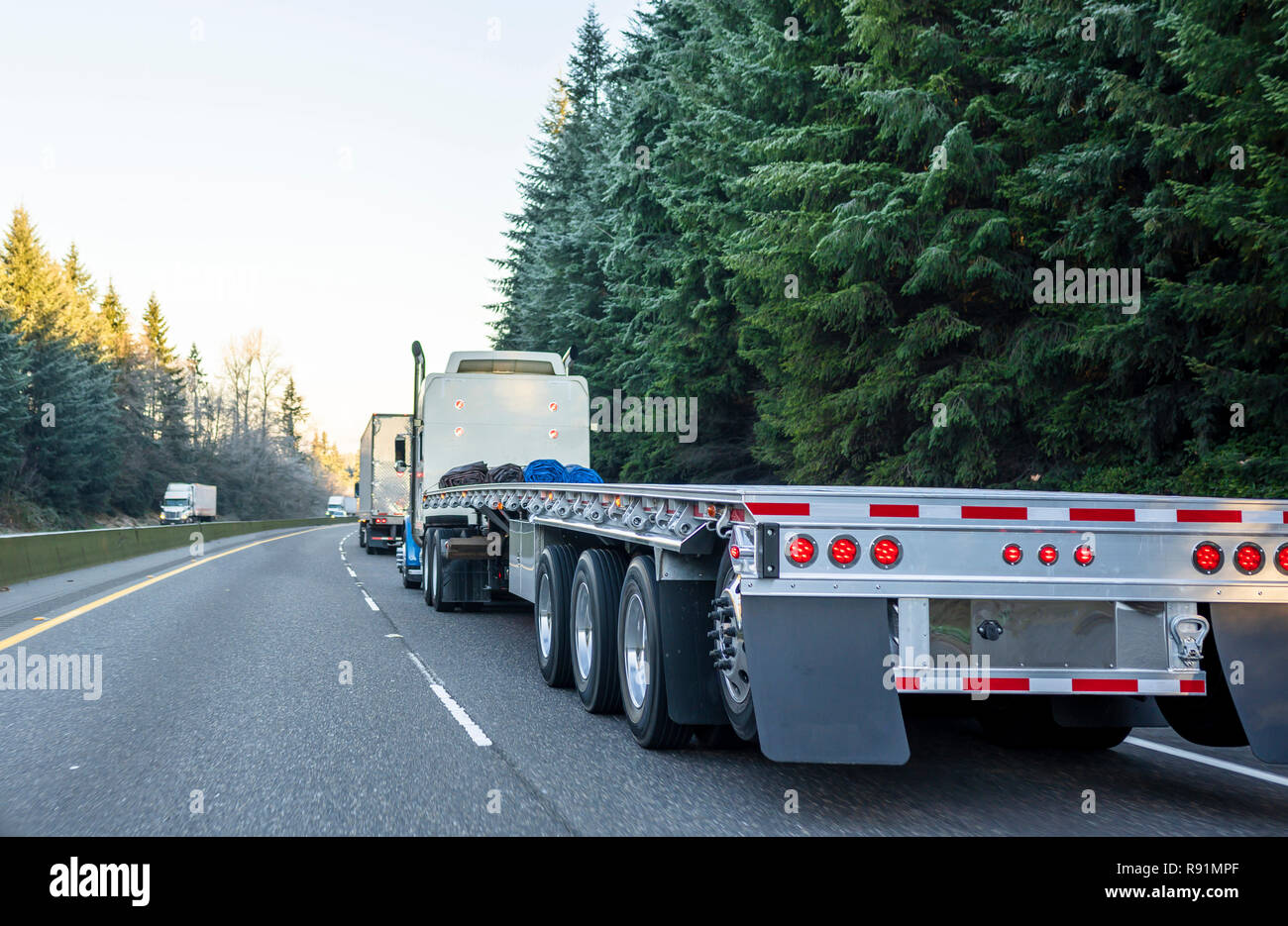 Gros Camion Camion semi puissante long-courrier avec en aluminium léger vide semi-remorque à plateau tournant sur le chemin d'hiver en convoi avec un autre demi tr Banque D'Images