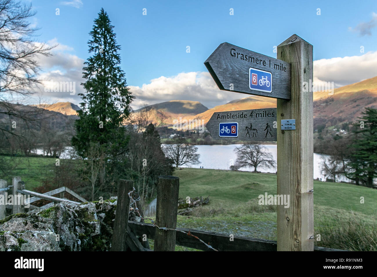 Bridleway/sentier/Cycle way signe indiquant la direction d'Ambleside et Grasmere en vue de Grasmere village & le lac et les montagnes au-delà. Lake Banque D'Images
