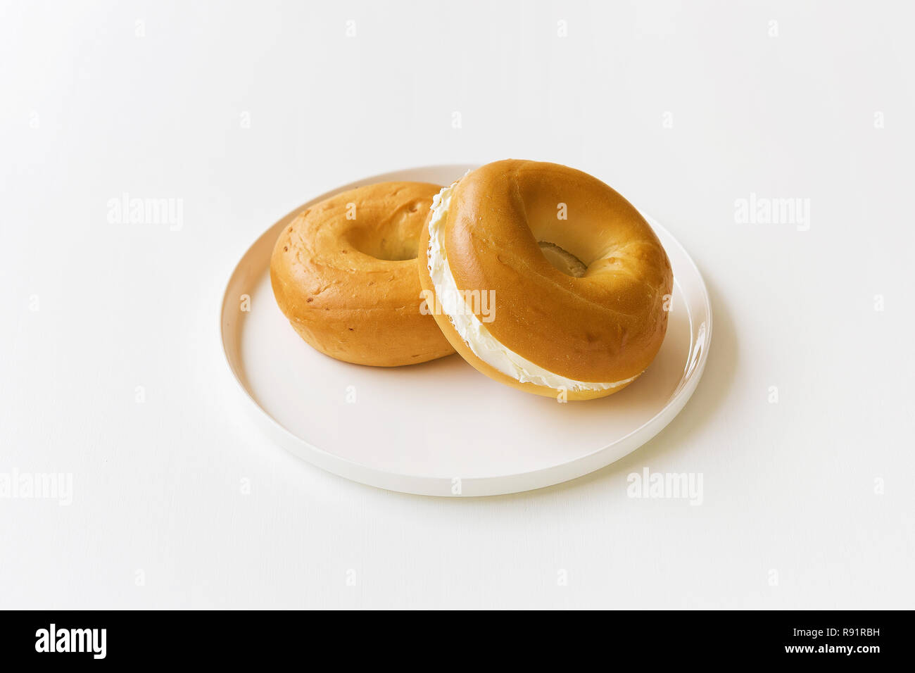 Le fromage à la crème les bagels sur un plateau blanc Banque D'Images