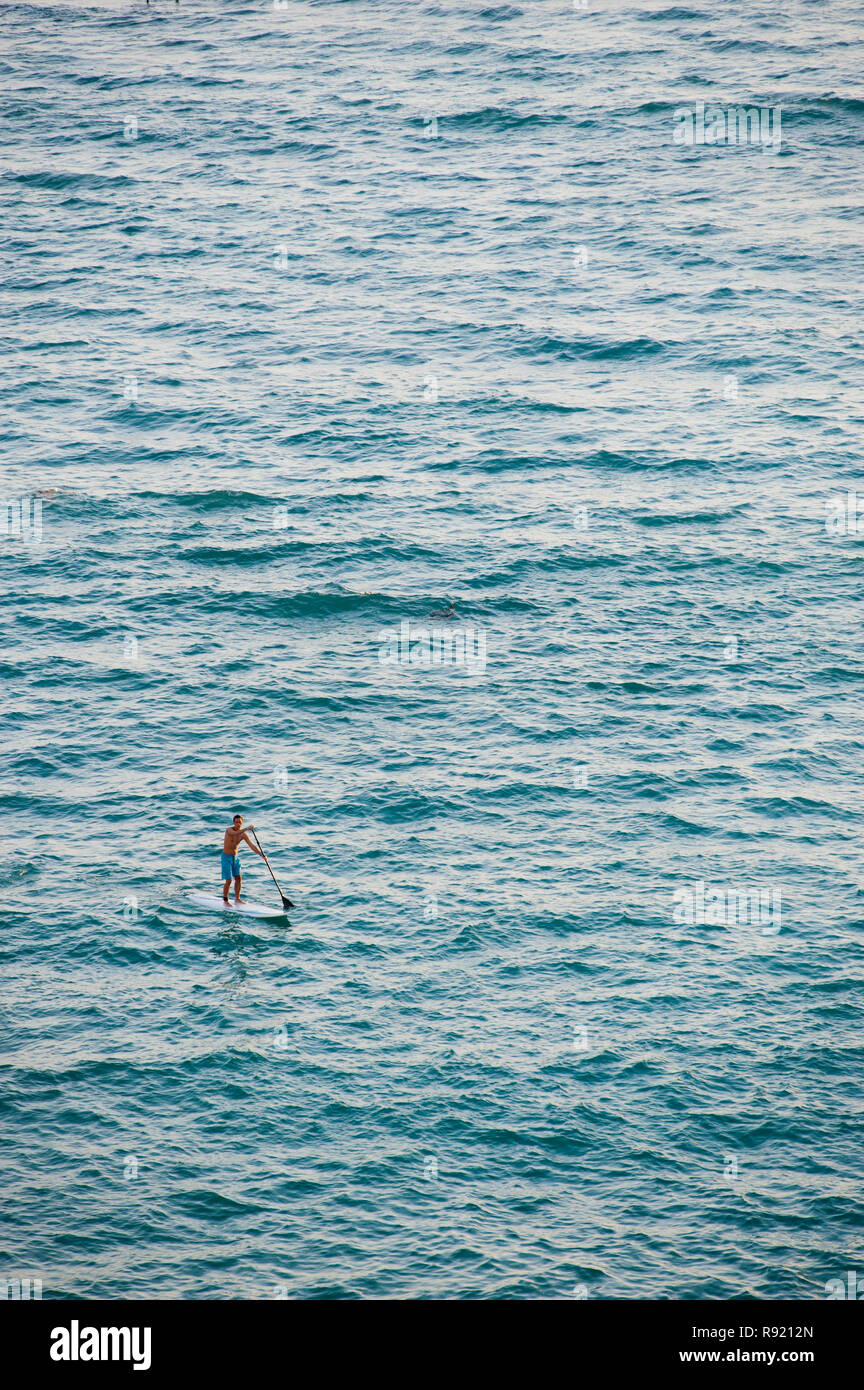 Vue lointaine d'un seul homme paddle in sea Banque D'Images
