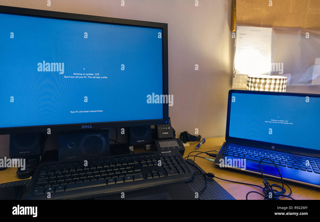 Deux ordinateurs PC Windows 10 côte à côte sur 24, bureau et ordinateur portable, la mise à jour simultanément, l'utilisateur laissant incapable de travailler Banque D'Images