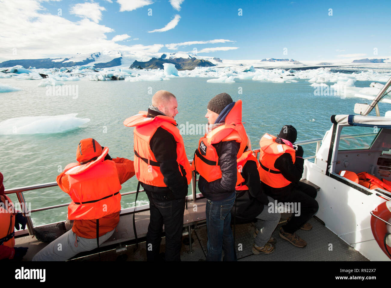 Circonscription tourisme dans un camion amphibie à la lagune glaciaire du Jökulsárlón, un des endroits les plus visités de l'Islande. Il a été créé par la régression rapide du glacier Breidamerkurjokull qui balaie en bas de la calotte glaciaire de Vatnajokull. Ice bergs mettent bas à l'avant et flotter dans le lagon avant de flotter sur la mer quand assez petit. Tous les glaciers reculent rapidement, et sont prévus pour disparaitre complètement dans les 100 prochaines années. Les films Batman et James Bond ont été filmés à la lagune de glace. Banque D'Images