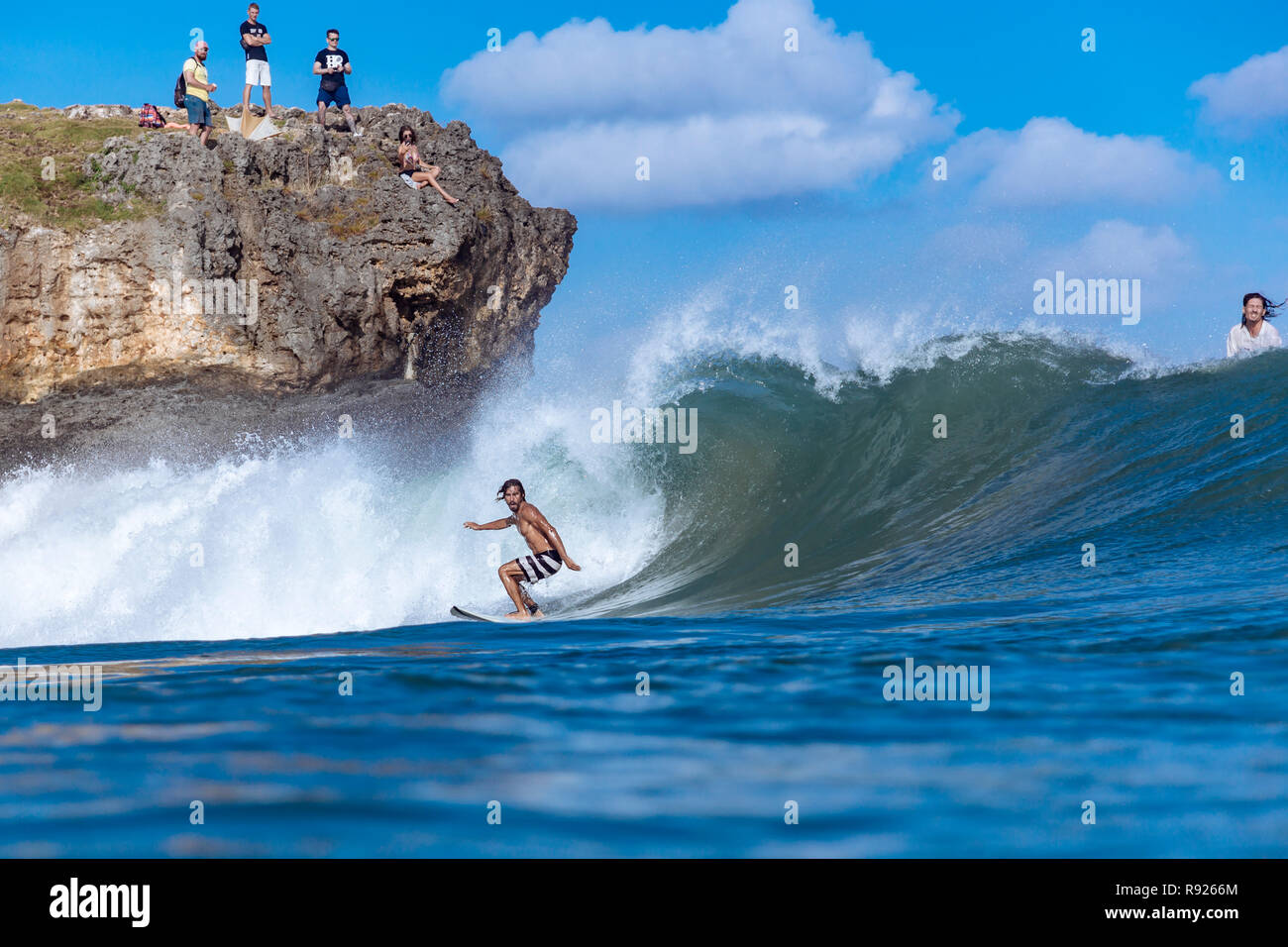 Voir de jeunes hommes Surfer la vague d'équitation en mer, Jimbaran, Bali, Indonésie Banque D'Images