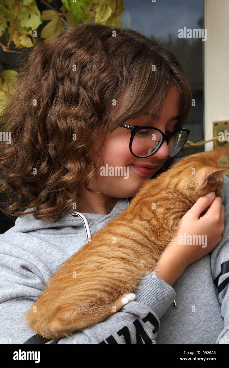 12 ans, fille, tenant le gingembre et le chaton blanc Surrey England Banque D'Images