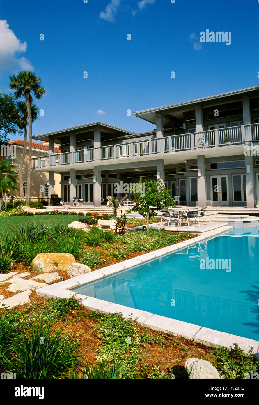 Vitrine de luxe accueil avec l'aménagement paysager entourant une piscine concepteur en arrière-cour, Florida, USA Banque D'Images