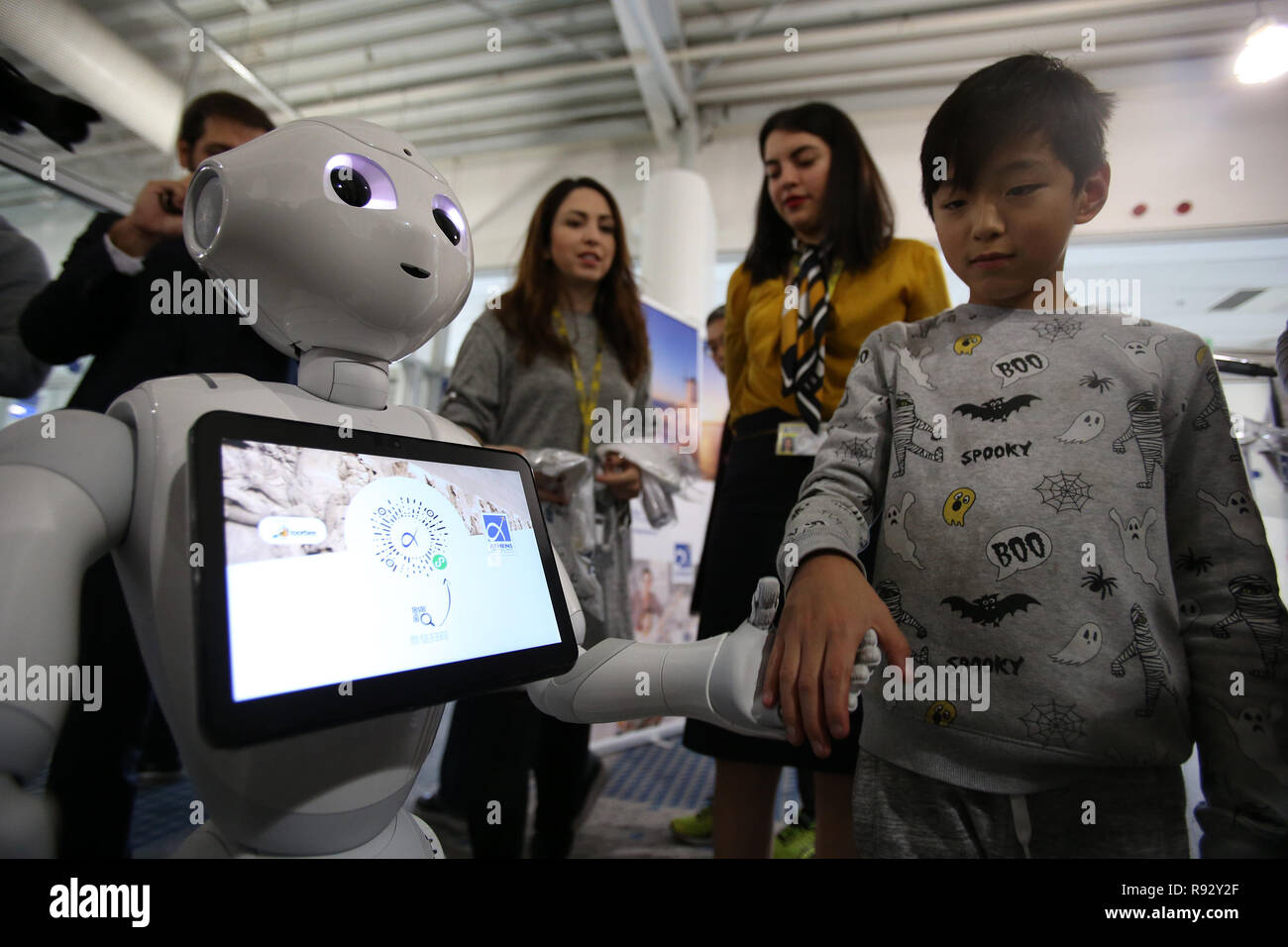 Athènes, Grèce. Dec 19, 2018. Un garçon interagit avec le poivre le robot, une assistance numérique montrant l'application 'AIA - Toorbee Miniapp WeChat,' à l'Aéroport International d'Athènes à Athènes, Grèce, le 19 décembre 2018. L'Aéroport International d'Athènes présenté mercredi ici une application pour appareils mobiles spécialement conçus pour les voyageurs chinois, visant à faciliter leur séjour à l'aéroport et de la capitale grecque. Credit : Marios Lolos/Xinhua/Alamy Live News Banque D'Images