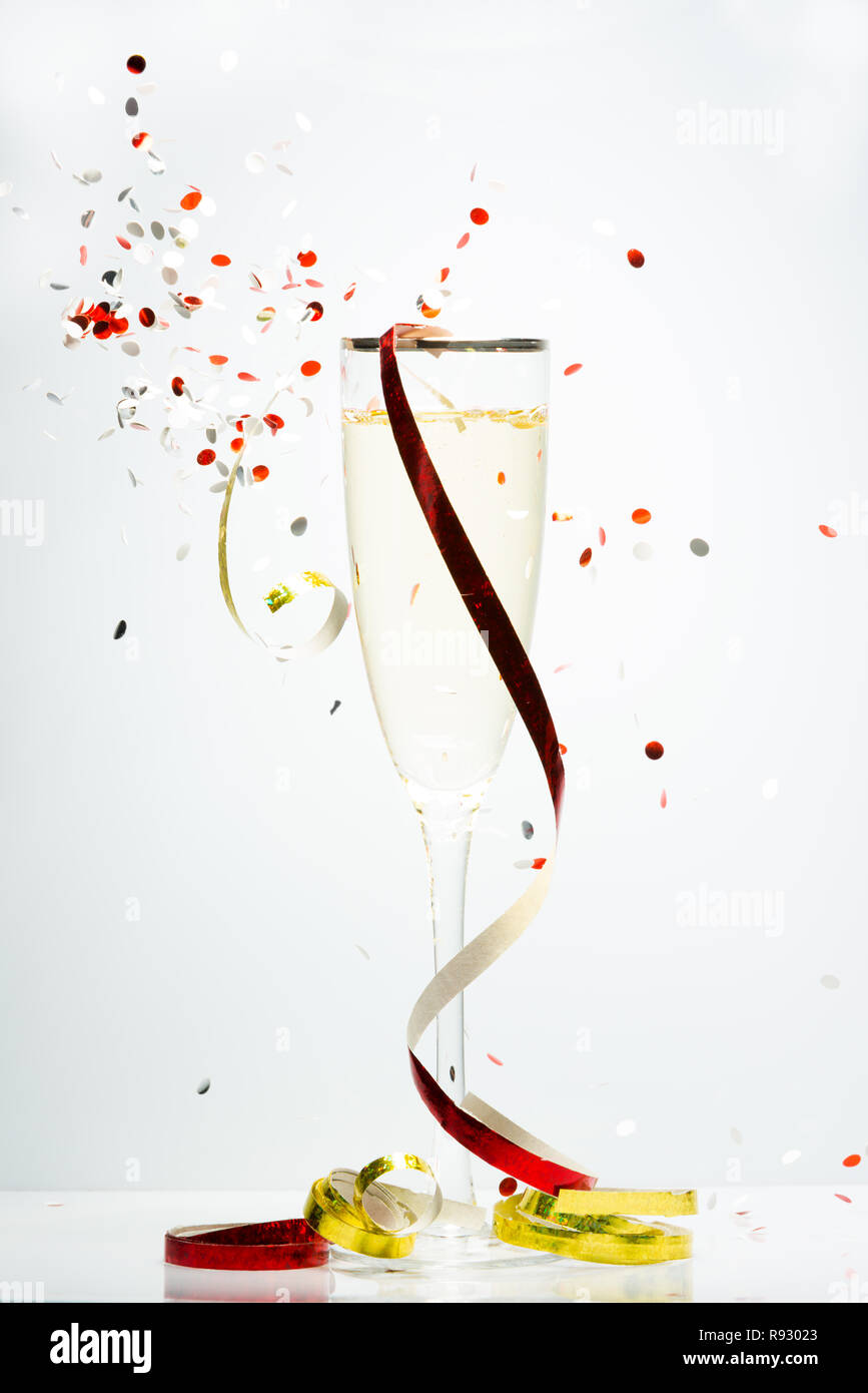 Concept représenté de confettis célébration autour d'un verre de Champagne Banque D'Images