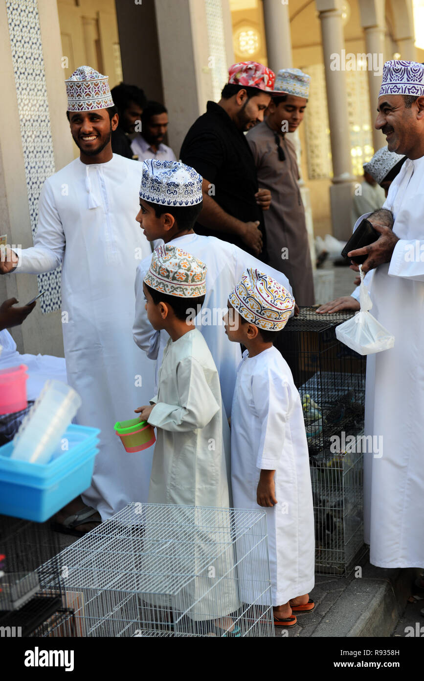 Les garçons omanais traditionnel portant des chapeaux à jalabiyas Kuma et  le marché du vendredi à Nizwa, Oman Photo Stock - Alamy