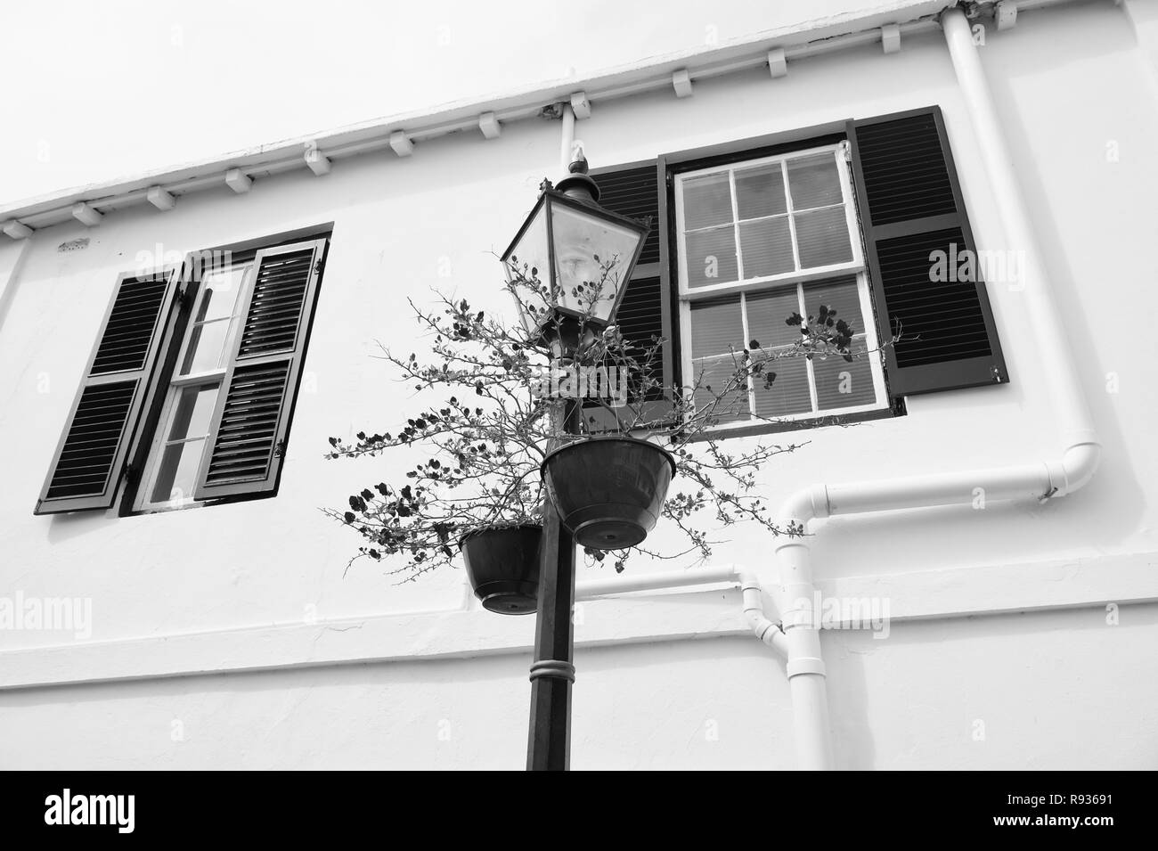 Lampe de rue avec les pots de fleurs sur façade de maison à Hamilton, aux Bermudes. Fleurs en pot sur la colonne d'éclairage avec lampe stree. Deco. Architecture et design lampe de rue. Paysage urbain. Banque D'Images