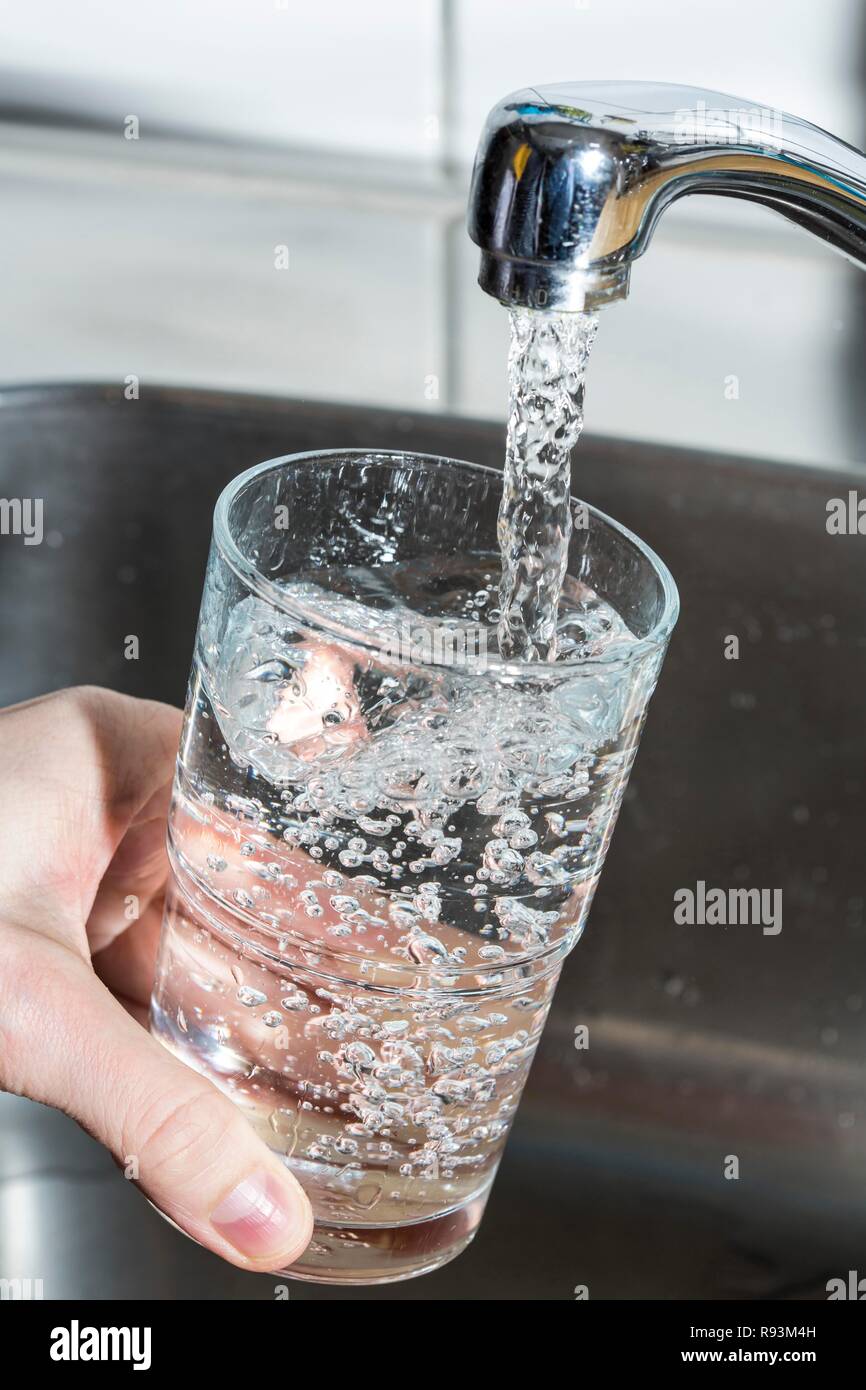 L'eau qui coule d'un robinet dans un verre Photo Stock - Alamy