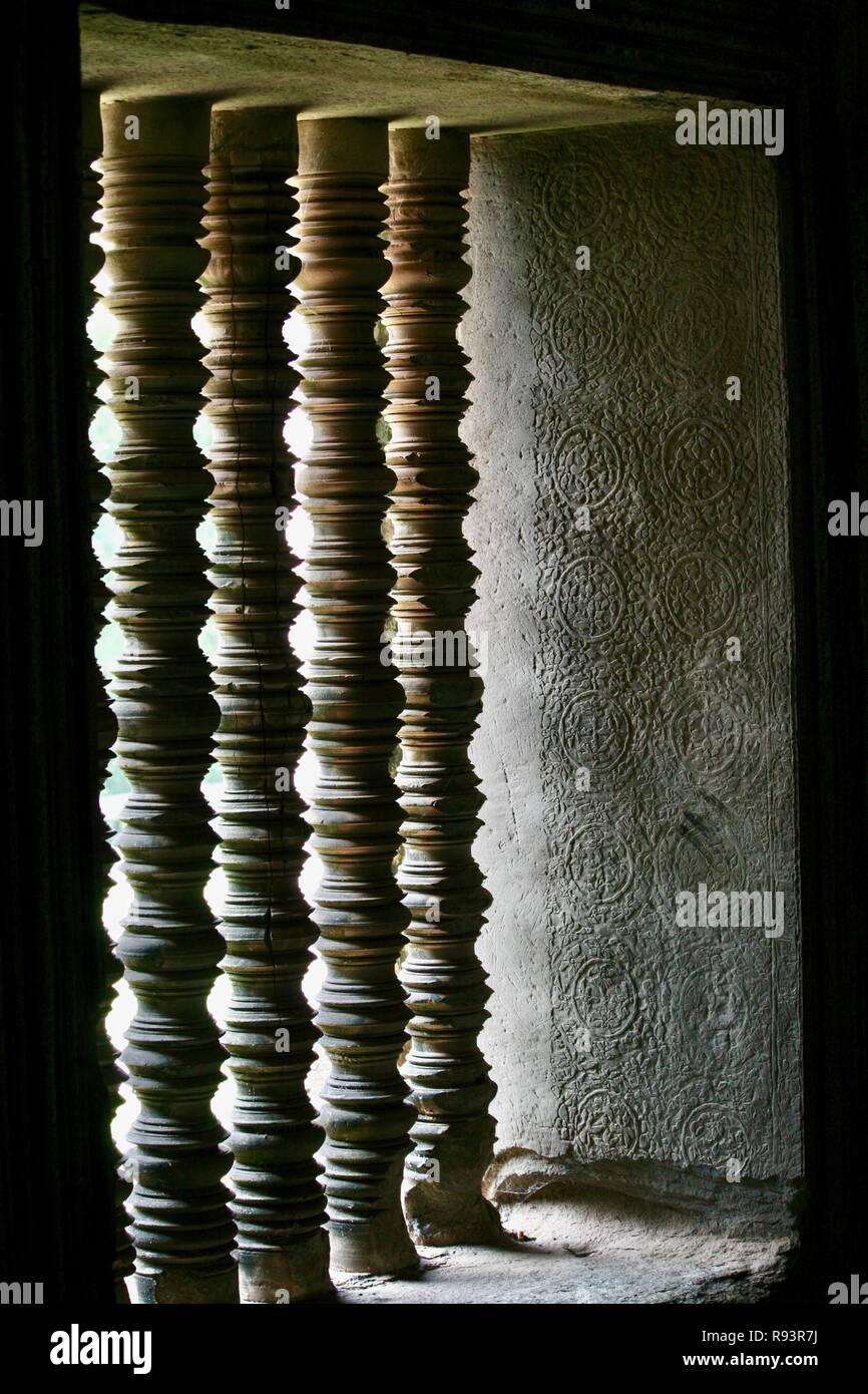 Ombre et lumière sur les barres en bois sculpté dans un temple cambodgien Banque D'Images